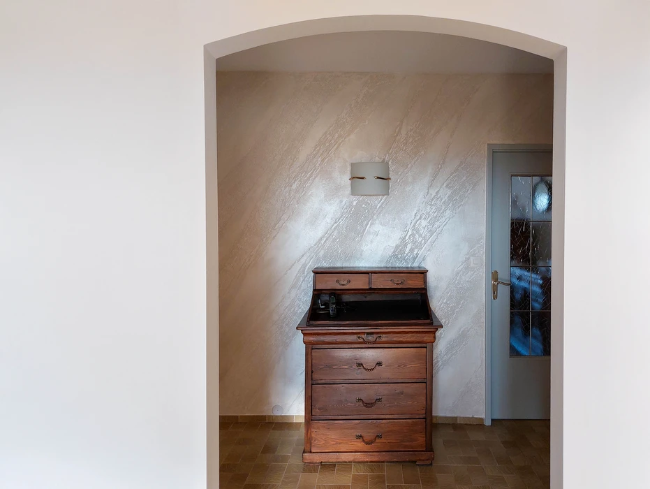Intérieur résidentiel avec bureau secrétaire en bois massif style classique, tiroirs à poignées ornementées, compartiment ouvert révélant l'intérieur