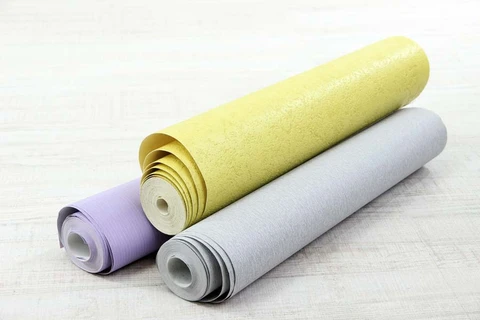 Scène d'intérieur avec rouleaux de papier peint déroulés sur surface claire