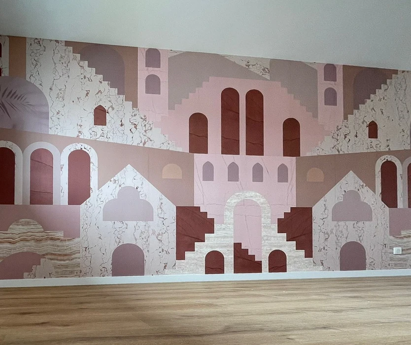 Mur peint d'un salon moderne présentant une fresque architecturale stylisée aux tons rose, blanc et terre cuite