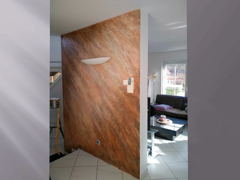 Intérieur moderne avec mur accent en travertin beige veiné, séparant cuisine et salon