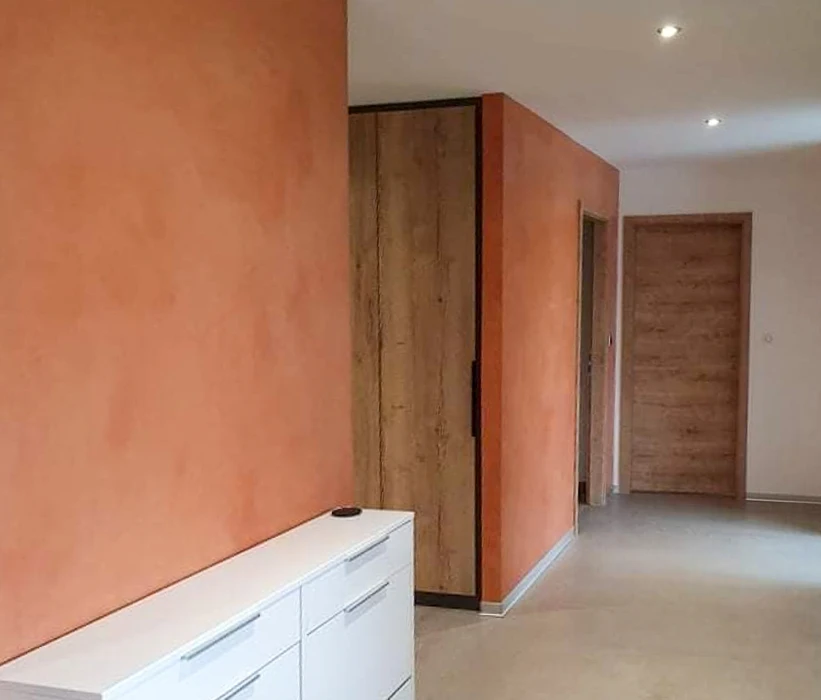 Salon moderne avec mur d'accent en lamelles de bois verticales, meuble TV gris anthracite, écran plat noir