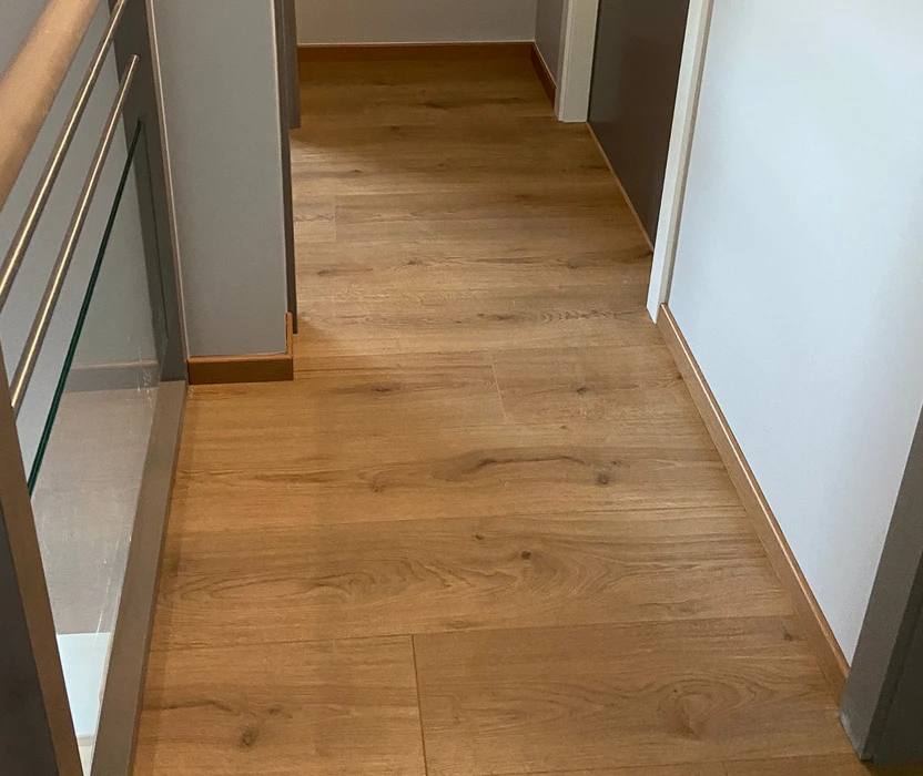 Escalier intérieur moderne avec mur d'accent texturé en pierre naturelle gris-brun s'étendant du sol au plafond