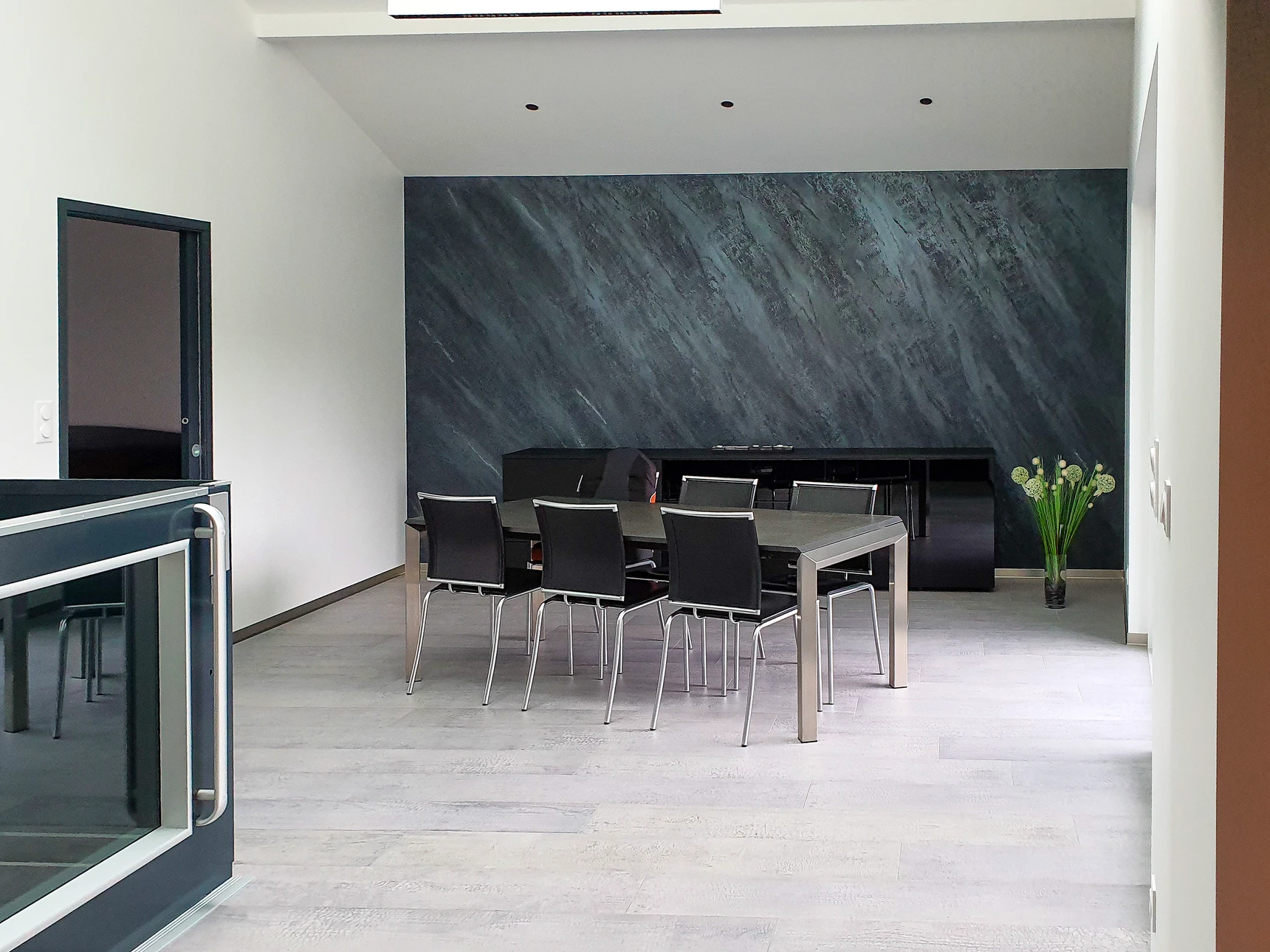 Espace intérieur moderne en cours d'aménagement avec sols carrelés gris, murs partiellement finis